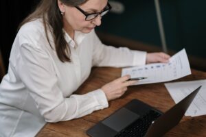 Senior woman in white blouse analyzing data